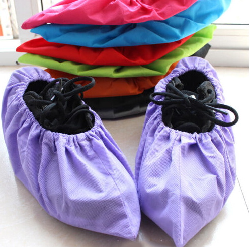 Shoe covers of various colors are stacked next to purple ones